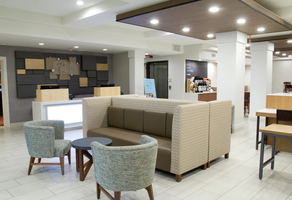 Renovated Tacoma hotel lobby with new signage, tile floors, LED lighting, reception desk, and furniture. 