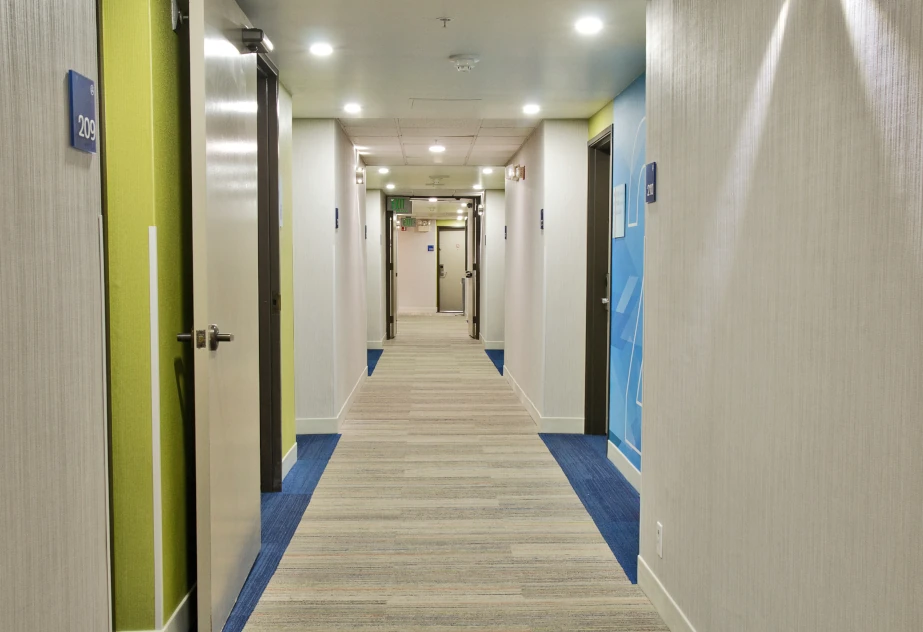 Holiday Inn Express Tacoma’s renovated guest room hallway has new carpet, paint, and LED lighting.