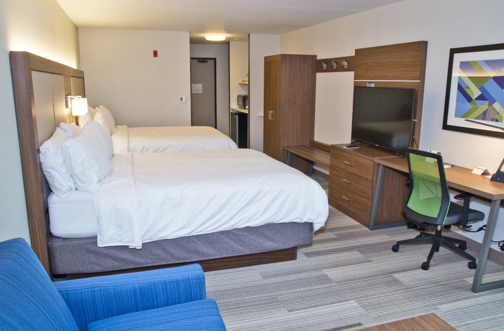 Tacoma, WA hotel guest room after renovation with new flooring, paint, lighting, and custom cabinetry.