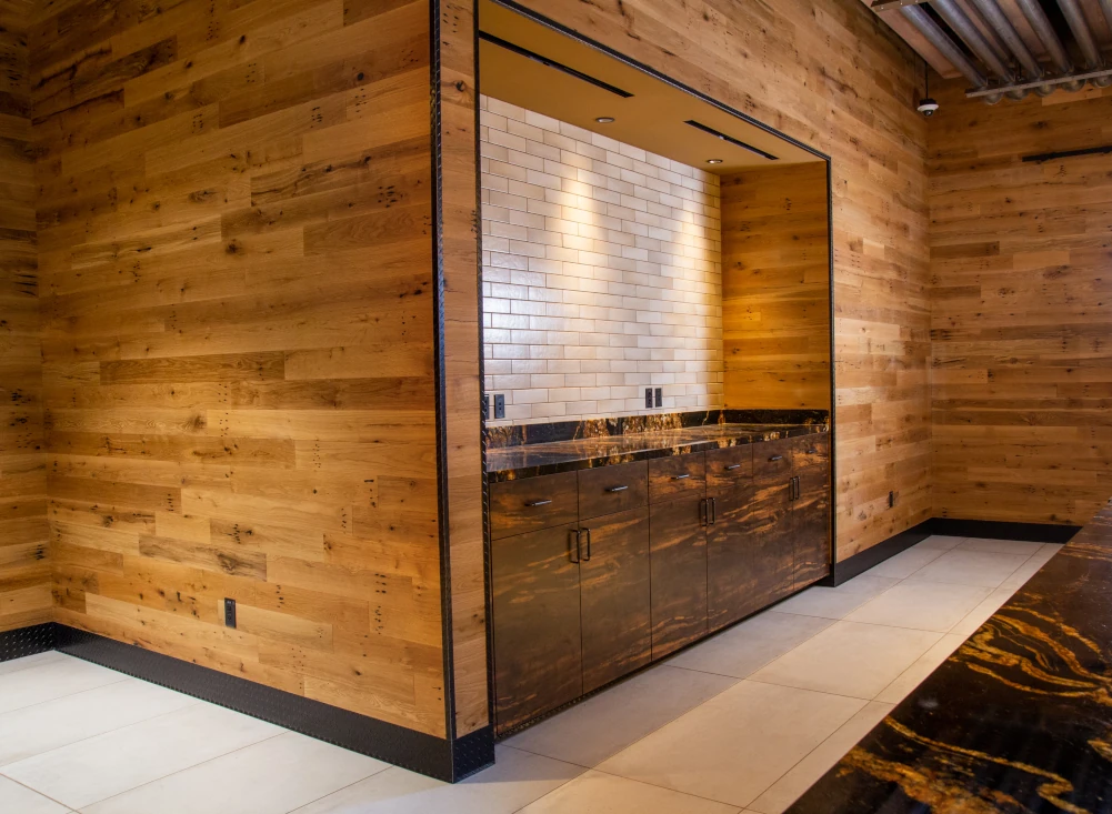 Rustic wood wall cladding and a service area with ceramic tiled walls and custom wood cabinetry.